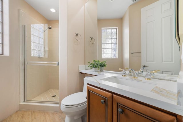 bathroom with tile patterned floors, vanity, toilet, and walk in shower