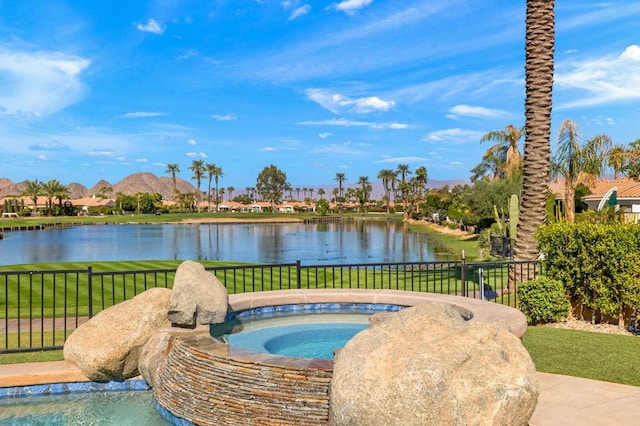 view of pool with an in ground hot tub, a yard, and a water view