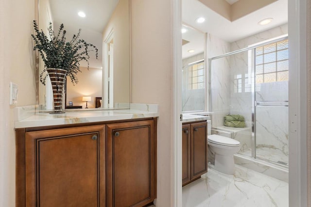 bathroom featuring vanity, toilet, and a shower with door