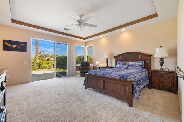 bedroom featuring a raised ceiling, access to exterior, ceiling fan, and light carpet