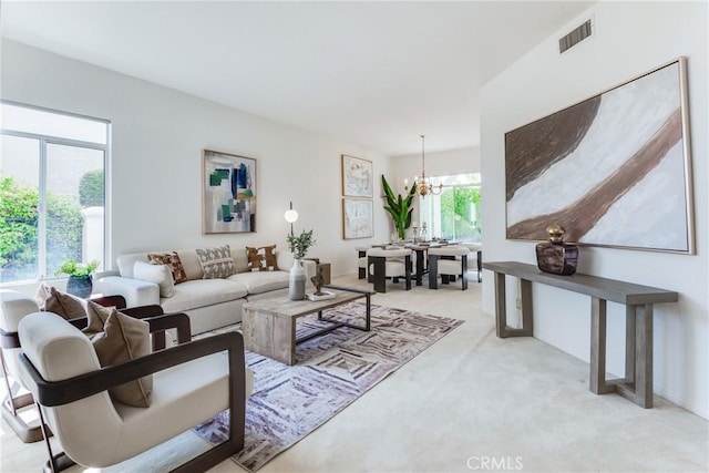 living room with light colored carpet and a notable chandelier