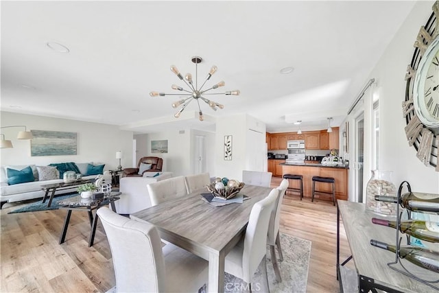 dining space with an inviting chandelier and light wood-type flooring