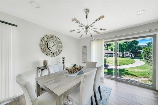 dining room with light wood-type flooring, an inviting chandelier, and a wealth of natural light