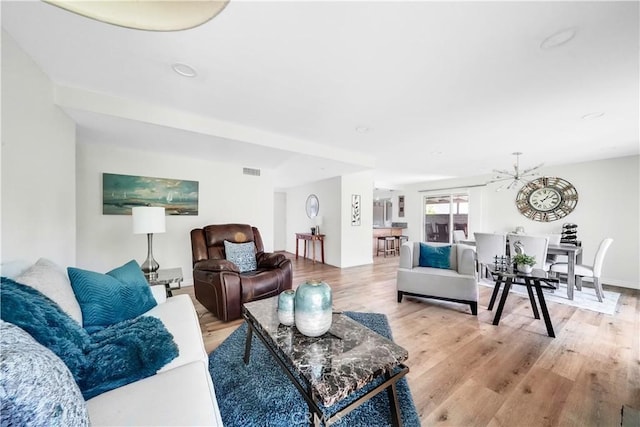 living room with a chandelier and light hardwood / wood-style floors