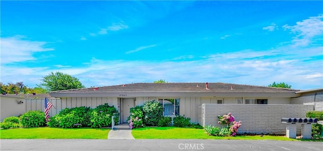 single story home featuring fence, a front lawn, board and batten siding, and brick siding