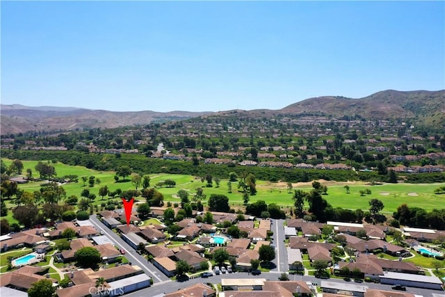 drone / aerial view with a residential view, a mountain view, and golf course view