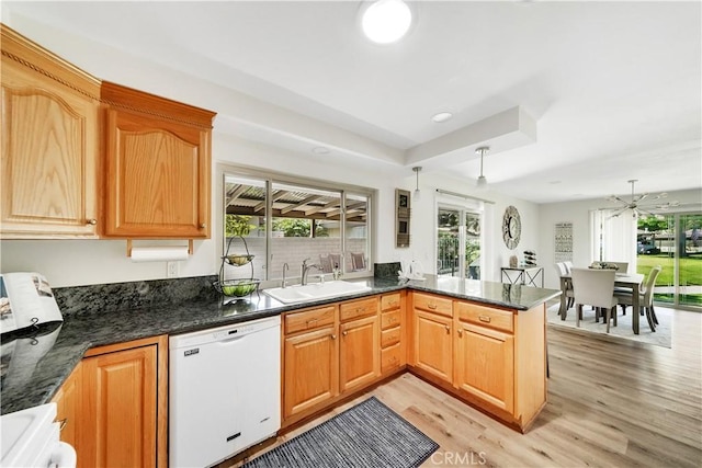 kitchen featuring white appliances, sink, ceiling fan, light hardwood / wood-style floors, and kitchen peninsula