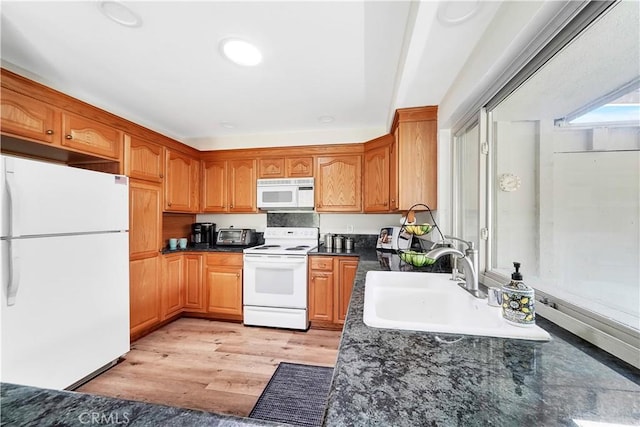 kitchen featuring light hardwood / wood-style floors, white appliances, and sink