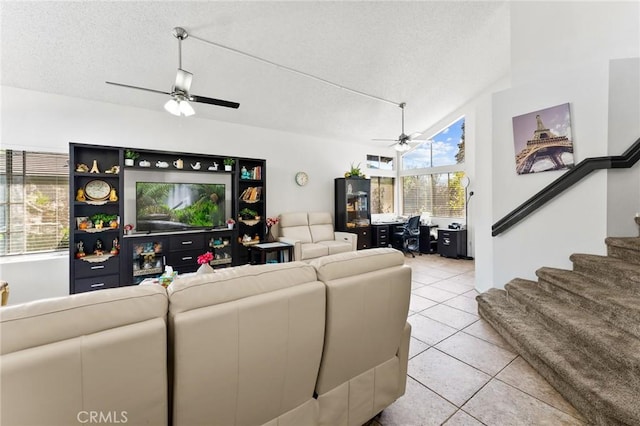 tiled living room with ceiling fan and a textured ceiling