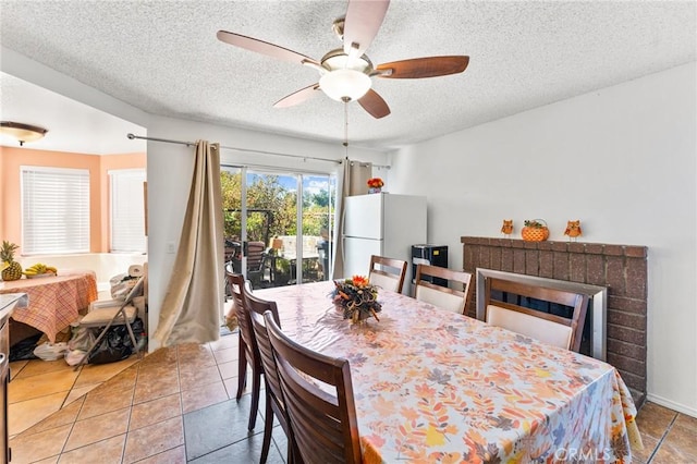 dining space with ceiling fan, light tile patterned flooring, and a textured ceiling