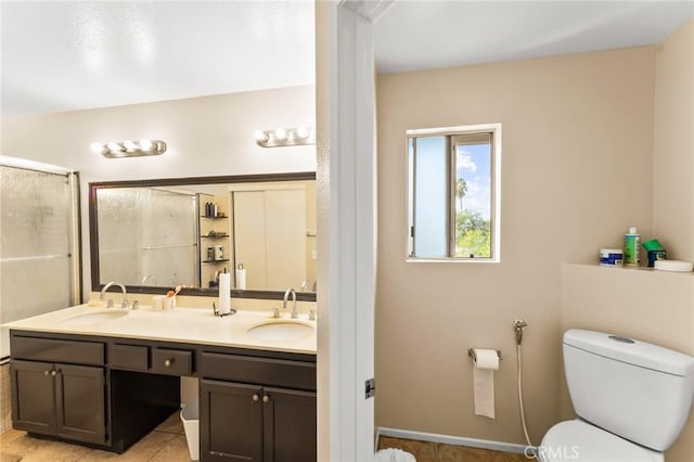 bathroom with tile patterned flooring, a shower with door, vanity, and toilet