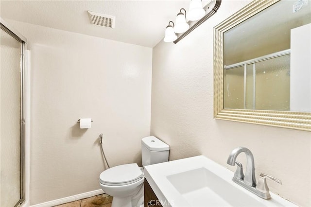 bathroom with tile patterned floors, vanity, toilet, and a shower with door