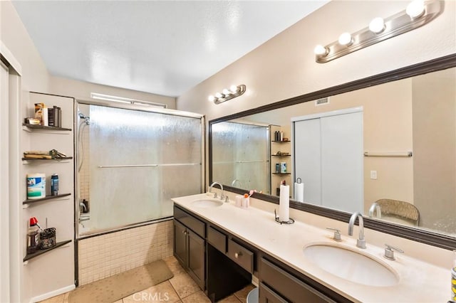 bathroom featuring tile patterned floors, vanity, and bath / shower combo with glass door