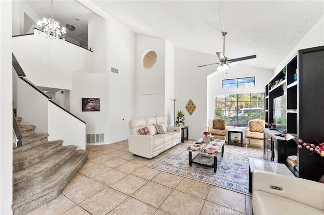 tiled living room featuring a textured ceiling, high vaulted ceiling, and ceiling fan with notable chandelier