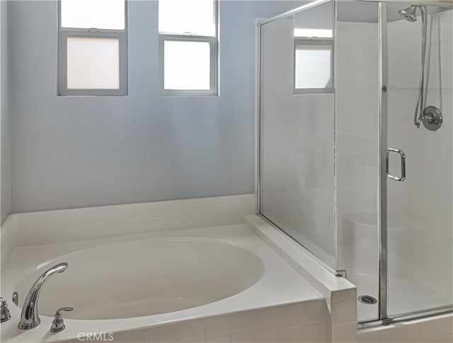 bathroom featuring shower with separate bathtub