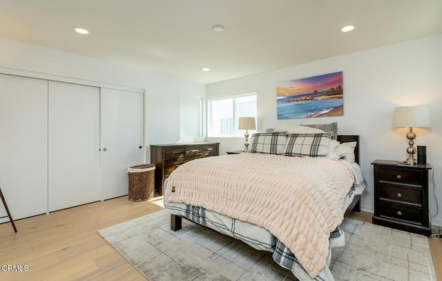 bedroom with a closet, recessed lighting, and light wood-style floors