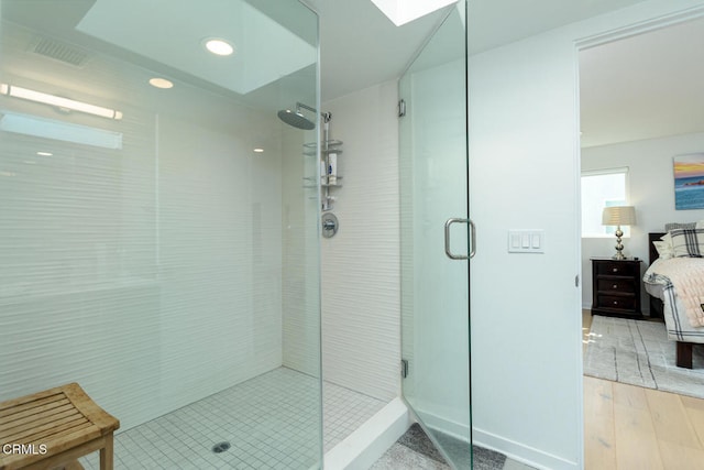 bathroom featuring hardwood / wood-style flooring and a shower with shower door