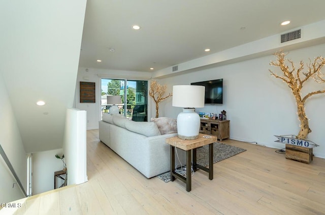 living area featuring recessed lighting, light wood-type flooring, and visible vents