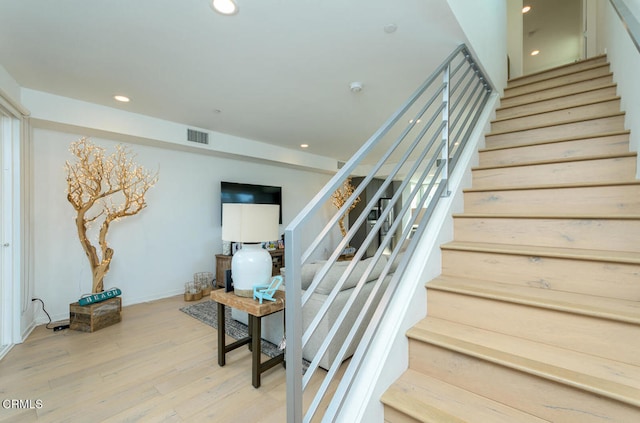 staircase with hardwood / wood-style floors