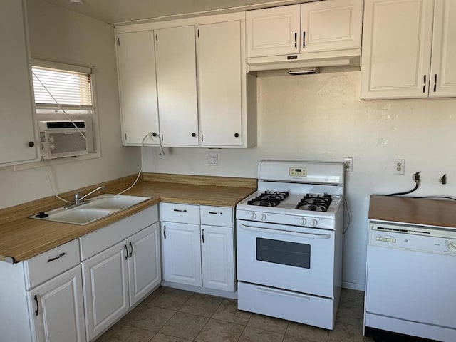 kitchen with white cabinetry, sink, white appliances, and dark tile patterned floors