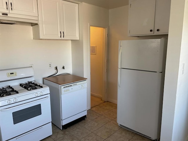 kitchen featuring light tile patterned floors, white cabinets, and white appliances