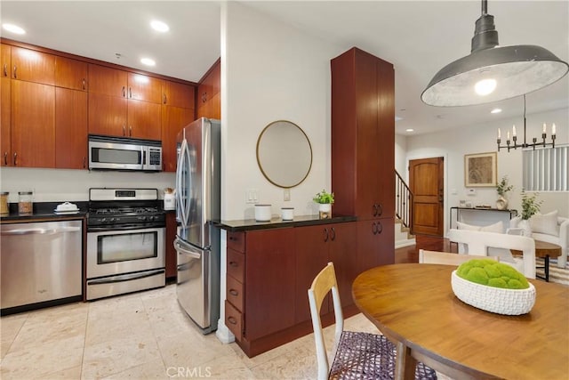 kitchen with appliances with stainless steel finishes, an inviting chandelier, and hanging light fixtures