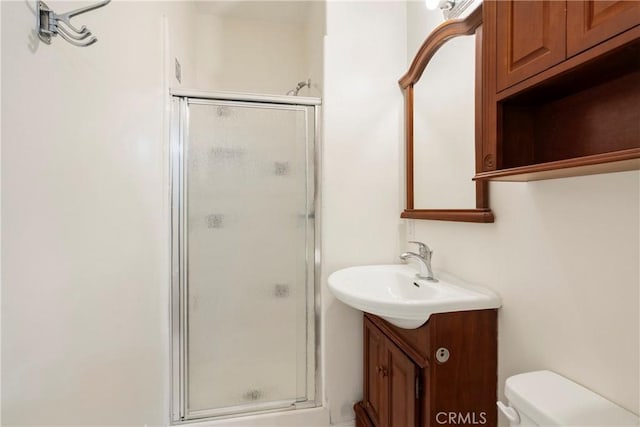 bathroom with walk in shower, vanity, and toilet