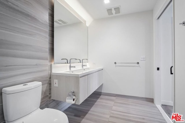 bathroom with hardwood / wood-style floors, vanity, and toilet