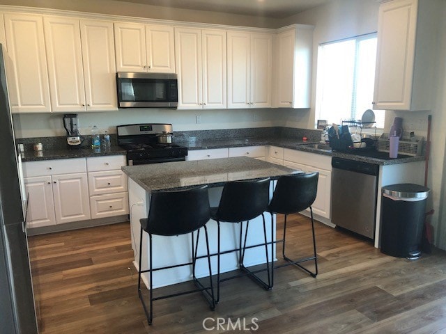 kitchen featuring a center island, white cabinets, stainless steel appliances, and dark hardwood / wood-style floors