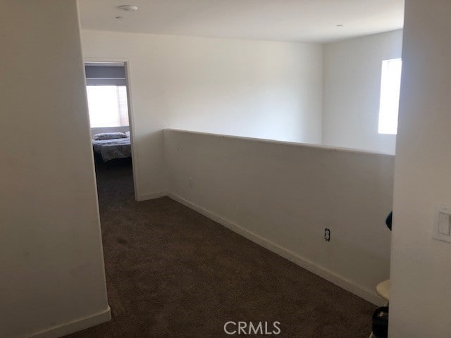 spare room featuring dark colored carpet