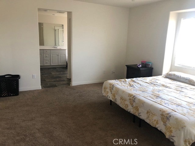 carpeted bedroom featuring ensuite bathroom