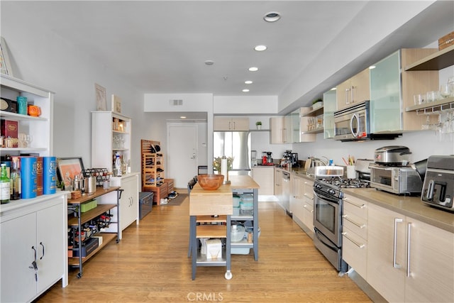 kitchen with stainless steel appliances and light hardwood / wood-style flooring