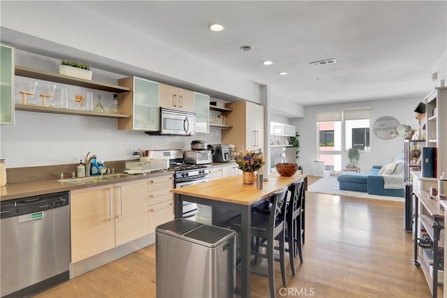 kitchen featuring sink, appliances with stainless steel finishes, light hardwood / wood-style flooring, and light brown cabinets