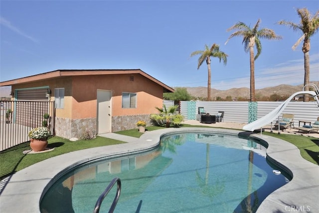 view of swimming pool featuring a water slide and a mountain view