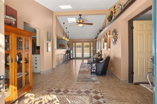 hall featuring high vaulted ceiling, tile patterned flooring, french doors, and a skylight