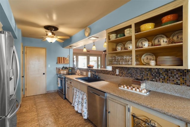 kitchen featuring sink, tasteful backsplash, light stone counters, and appliances with stainless steel finishes