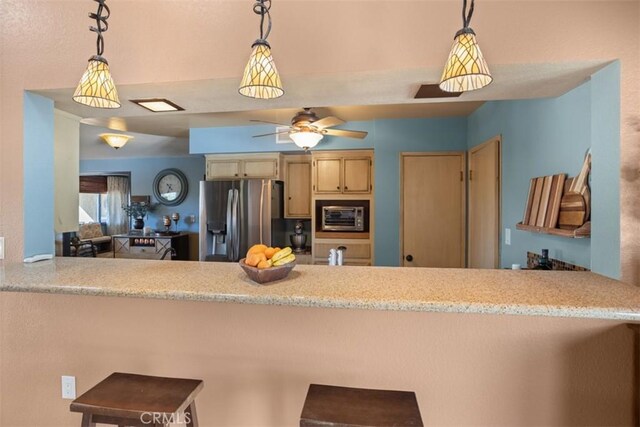 kitchen featuring appliances with stainless steel finishes, decorative light fixtures, and kitchen peninsula