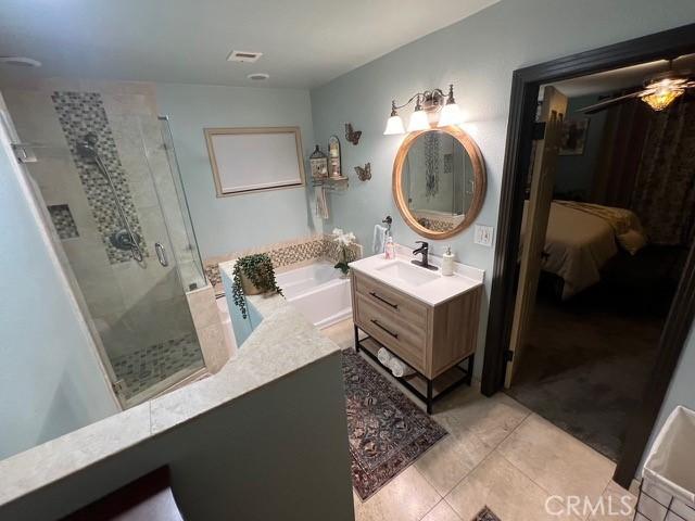 bathroom with vanity, plus walk in shower, and tile patterned floors