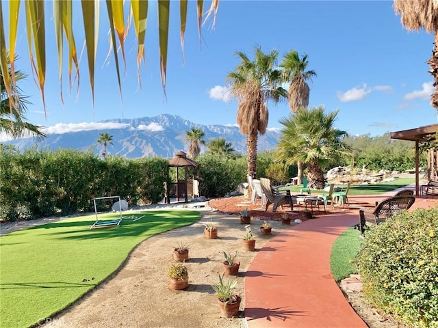 view of community with a lawn, a gazebo, and a mountain view