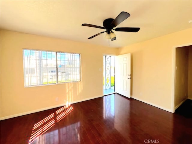 empty room featuring ceiling fan and dark hardwood / wood-style flooring