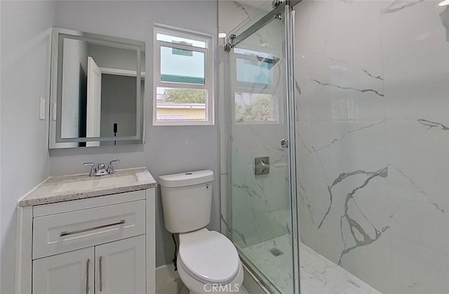 bathroom with vanity, toilet, and a shower with shower door