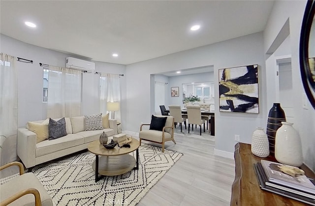 living room featuring an AC wall unit and light hardwood / wood-style floors