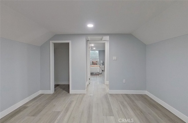 bonus room featuring light wood-type flooring and vaulted ceiling