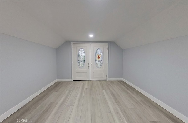 entryway with light hardwood / wood-style floors and vaulted ceiling