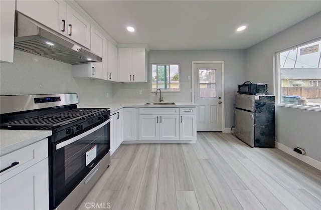 kitchen featuring sink, white cabinets, stainless steel appliances, and light wood-type flooring