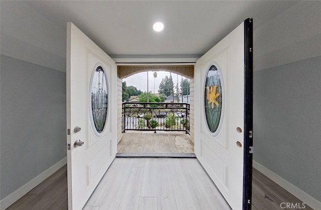 foyer entrance with hardwood / wood-style floors and vaulted ceiling