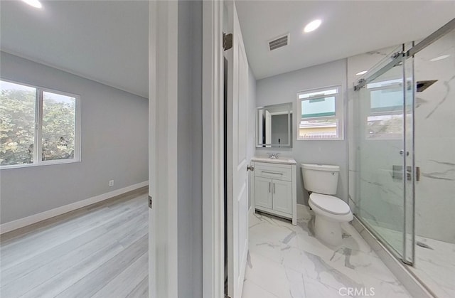 bathroom with vanity, hardwood / wood-style flooring, toilet, and a shower with door