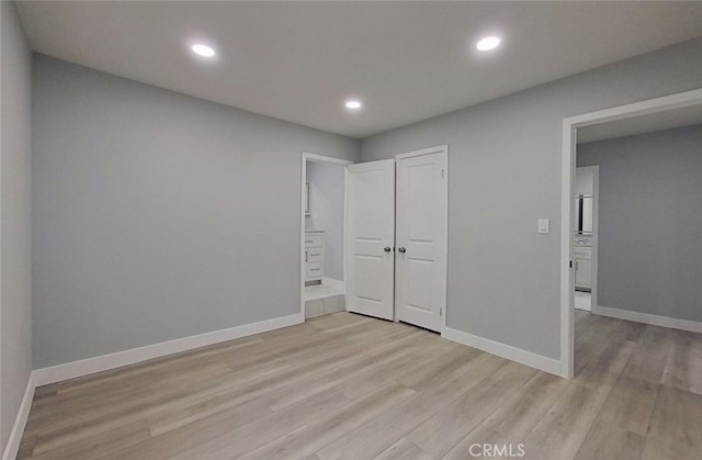 unfurnished bedroom featuring light hardwood / wood-style flooring and a closet