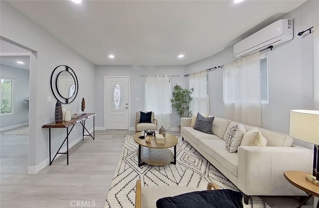 living room featuring a wall mounted AC and light hardwood / wood-style flooring