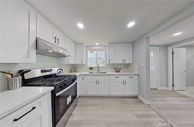 kitchen with white cabinetry, sink, light hardwood / wood-style floors, and stainless steel range oven